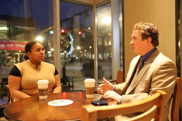 male alumnus and female law student sit together at a table at Starbucks