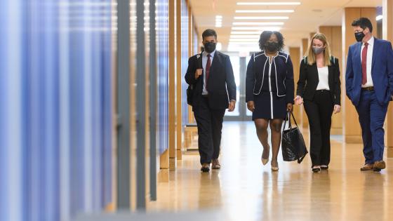 four students in business attire walking down hallway