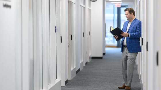 man standing in a hallway with binder